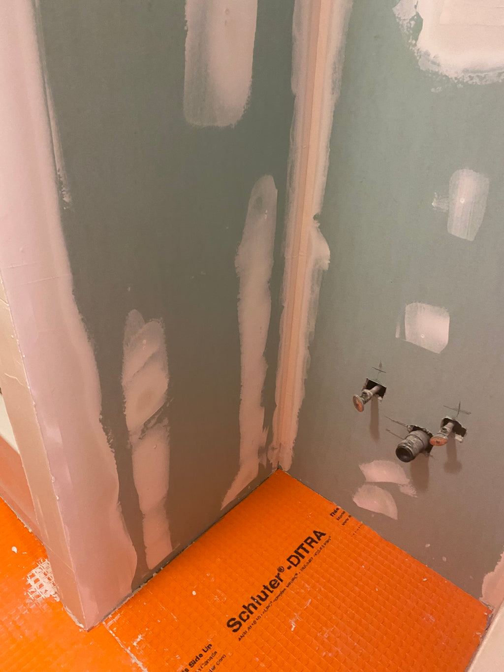 Ceiling with drywall patches and an orange  water proofing 