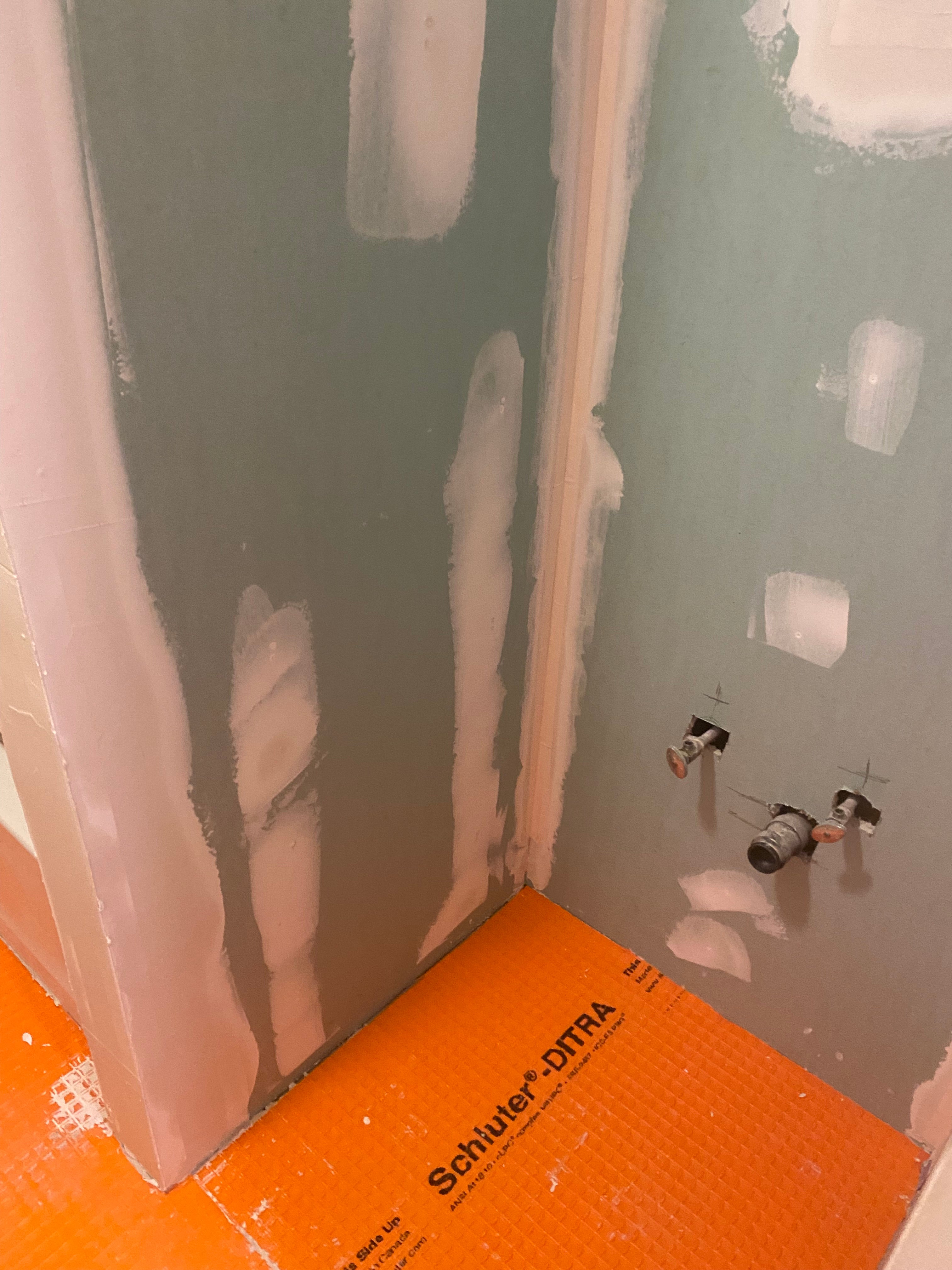 Ceiling with drywall patches and an orange  water proofing 