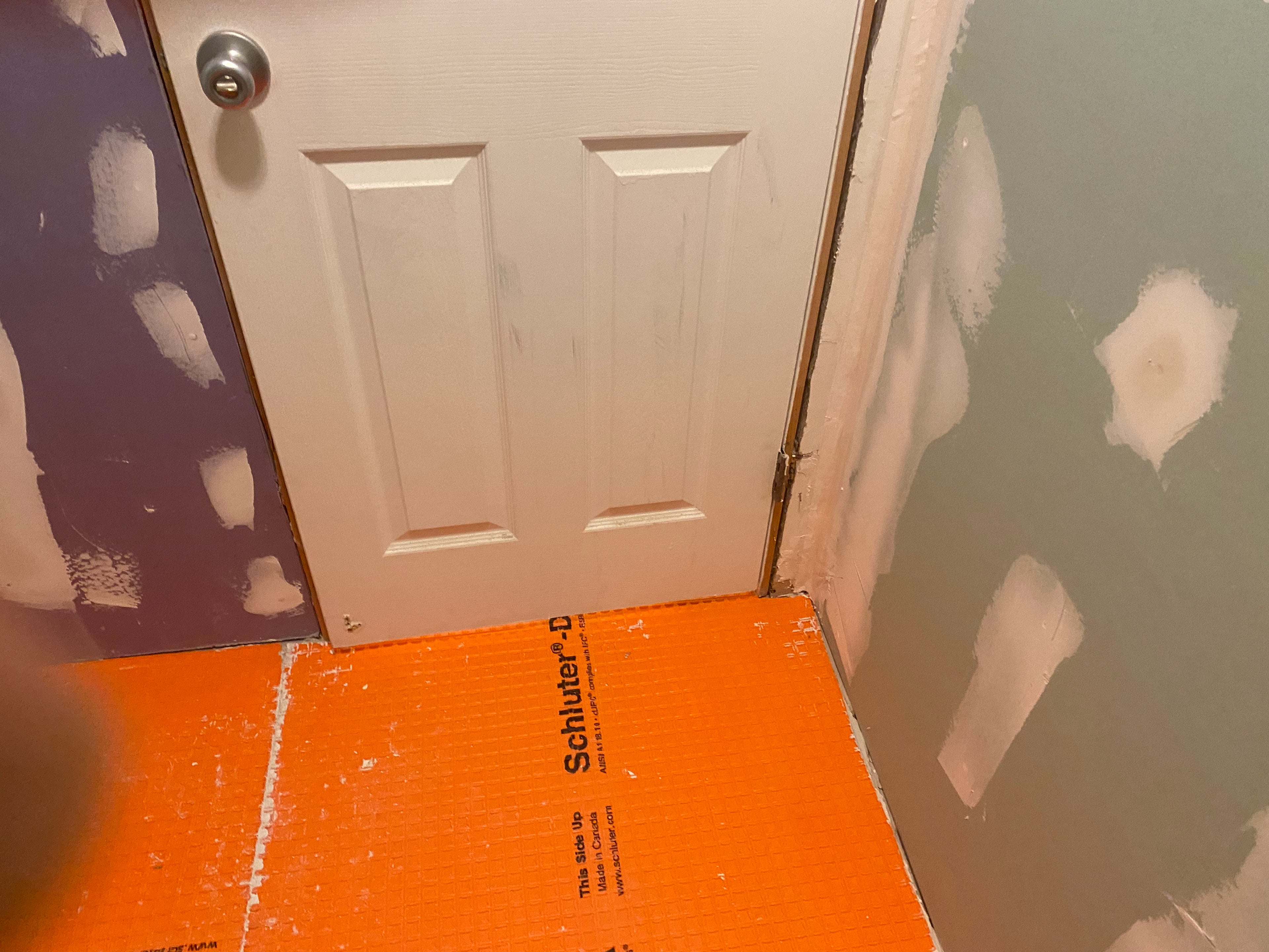 Orange floor underlayment with a white door in the background