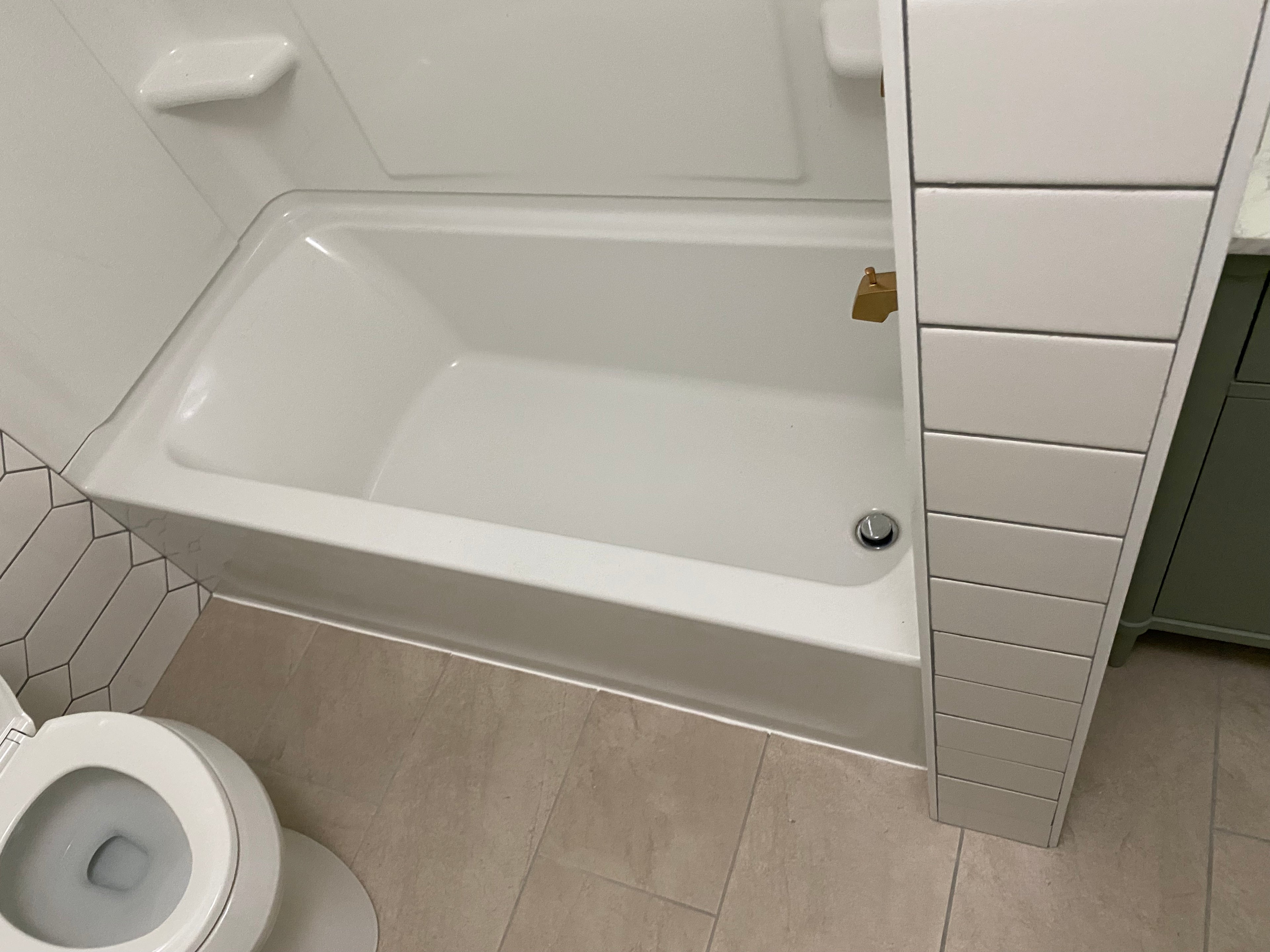 New deep soaker tub and white wall enclosure
