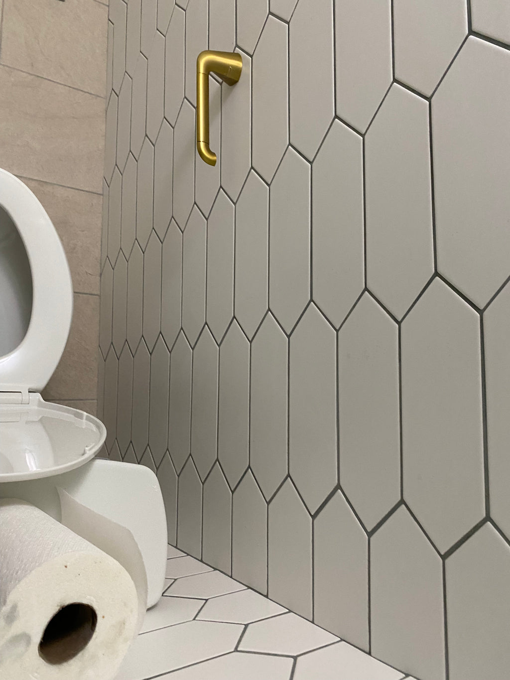 finished white tiles on the wall and new tissue holder