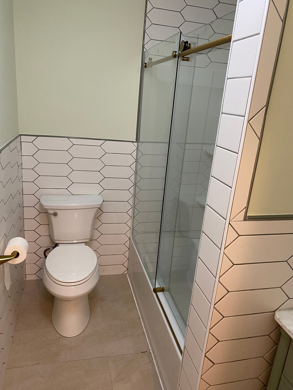 finished bathroom with new toilet and tiled walls and floor and painted walls